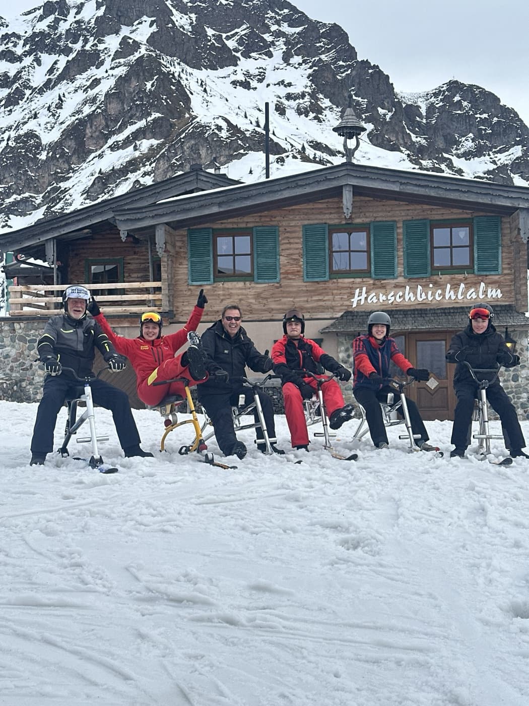 Skiers outside a Tirolean mountain hut on a grey winter afternoon